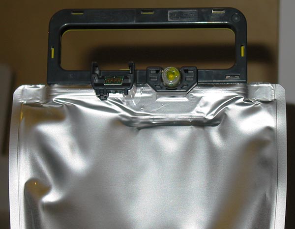 На жесткой пластиковой рамке в верхней части емкости имеется клапан для подсоединения к системе подачи чернил печатающего устройства и миниатюрная печатная плата с чипом