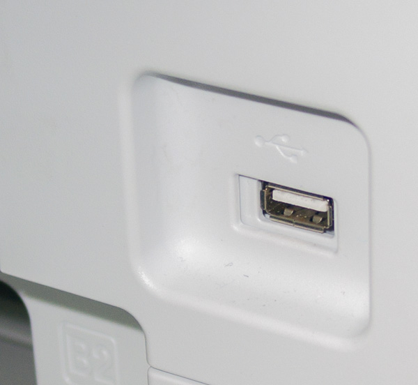 На передней панели корпуса МФУ имеется порт USB для подключения портативных накопителей