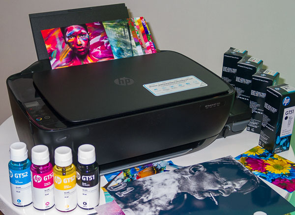 МФУ DeskJet GT 5820 с набором расходных материалов и образцами отпечатков