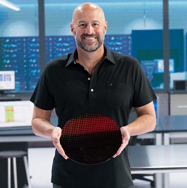 Грегори Брайант, исполнительный вице-президент и руководитель подразделения клиентских устройств Intel, демонстрирует образец процессора Intel Core 11-го поколения (cверху) и кремниевую пластину, на которой изготавливаются кристаллы